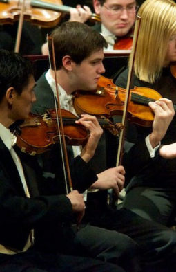 Josh Kaminksi playing a violin at a concert