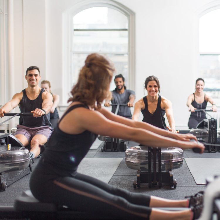 A group of people indoors on rowing machines