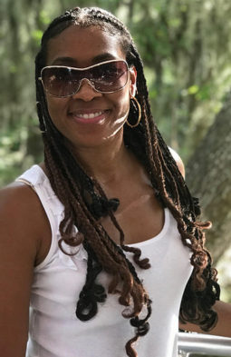 Derricka Peoples Black smiling with a green nature background