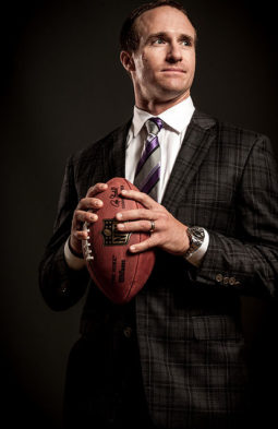 Drew Brees professional photo, in a suit carrying a football