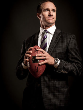 Drew Brees professional photo, in a suit carrying a football