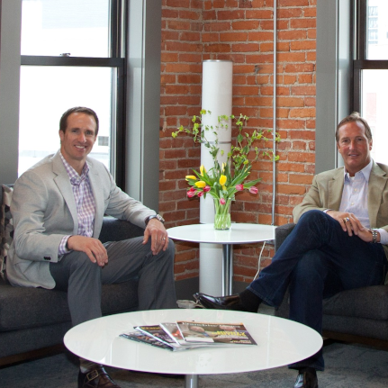 Drew Brees sitting next to John Rotche in his office