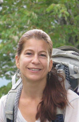 Kristen Sherwood smiling with a hiking backpack on outside