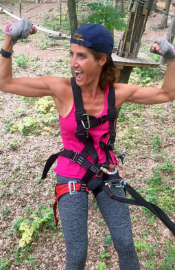 Meg Roberts flexing her muscles on a ropes course