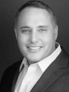 A headshot of a male smiling