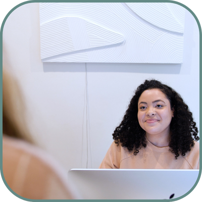 An employee at a sugaringLA location interacting with a customer behind a desk, providing personalized service and assistance.