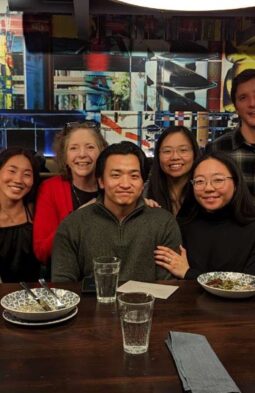 Kathleen and her family sitting at a dim-lit restaurant gathered together and smiling