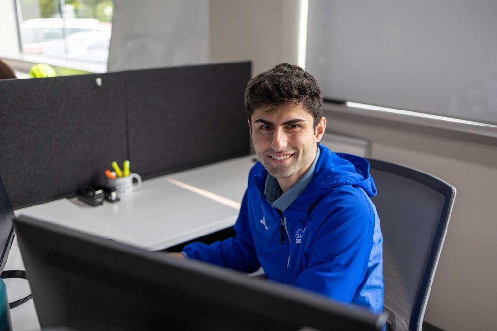 Intern Bryan sitting at his desk smiling