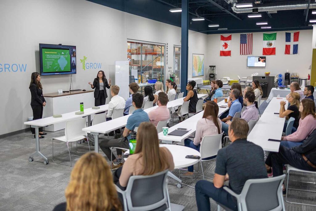 A group on Franworth employees and interns watching interns give a presentation