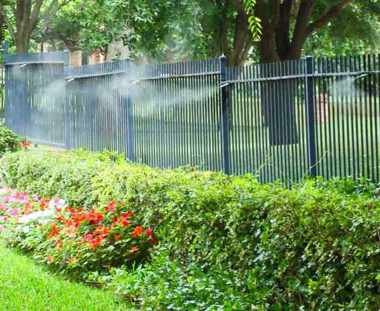 MosquitoNix misters installed on a fence in a lush backyard