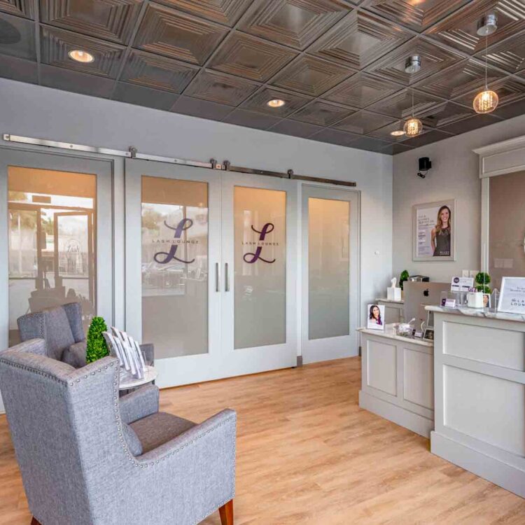 The Lash Lounge Lobby and front desk, with sliding doors and a cozy sitting area.